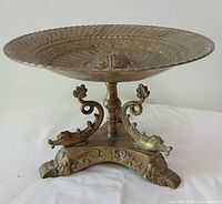 Side view of entire bronze tazza showing bowl, stem, dolphin supports and base