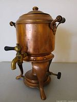 Full view of copper samovar on tripod stand with lid and handles