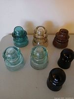 Six of the seven glass insulators showing colour variety