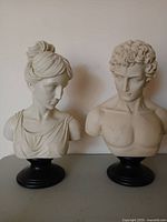 Front view of both bust sculptures on table