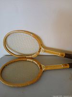 Two vintage Rawlings wooden tennis rackets overlapping, front view