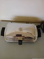 Closed grill showing chrome lid with indicator and side handles
