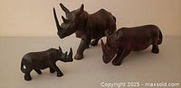 Front view of all three wooden rhinoceros figurines