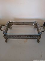 Glass casserole dish seated in ornate silver-plated footed stand