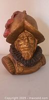 Front view of gold-painted Spanish conquistador bust with plume and ruff collar