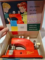 Machine inside open box showing graphics and accessories