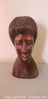 Front view of carved wood African bust showing facial details and overall form