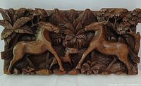 Full view of carved wooden panel showing horse family scene