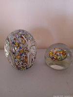 Both paperweights side by side for size comparison