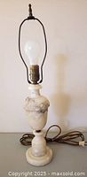 Full view of alabaster lamp showing harp, bulb, cord