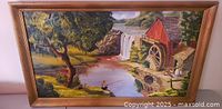 Full view of framed oil painting showing country landscape with red watermill, waterfall, river and figures