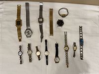 All 13 wristwatches laid out to show variety of styles and condition
