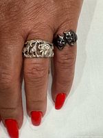 Both sterling silver rings worn on hand showing designs
