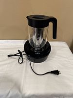Full view of Instant brewer with glass carafe, handle, base and cord