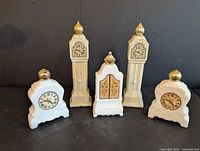 Group shot of all five Avon clock-shaped decanters