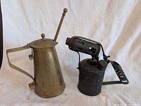 Brass kettle and blow torch side by side