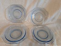 Set of four blue depression glass saucers displayed