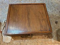 Closed top view showing wood grain and brass handle