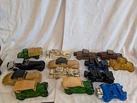 Group shot of all fourteen Avon car and truck decanters on white backdrop