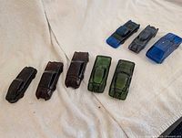 Eight glass car-shaped decanters on towel