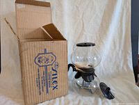 Coffee maker assembled beside original box and lid