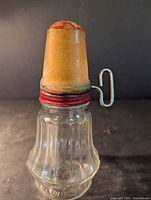 Full view assembled nut grinder showing glass jar and wood cover fitted