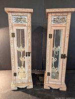 Front view of both wooden lanterns showing overall design, glass doors, carved trim