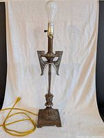 Full view of metal and glass Art Deco style table lamp with bulb and cord