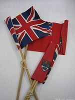 Two Union Jack and two Canadian Red Ensign flags on sticks, bundled
