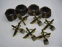 Group shot of 4 wooden and 6 brass napkin rings