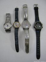 All four watches laid out: Swiss Military, Mickey Mouse Timex, Hello Kitty, digital sport