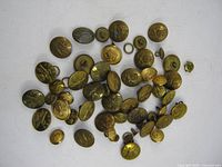 Pile of assorted brass uniform buttons, mixed sizes and designs