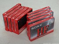 Front view showing eight cassettes on edge and two flat, displaying Sony HF branding and 90-minute marking