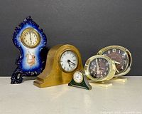 Group of five assorted clocks facing forward