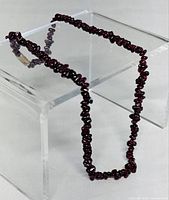 Full necklace draped to show continuous strand of garnet chips