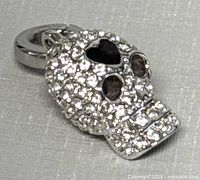 Front view of Swarovski crystal pavé skull charm showing heart cutout and eye sockets