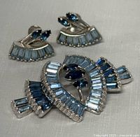 Front view of brooch and earrings showing rhinestone design