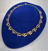 Necklace displayed on blue hat showing overall look