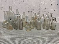 full group of 27 assorted glass bottles front view