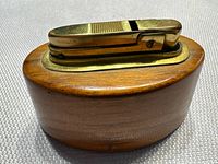 Side view of oval wood base and brass lighter insert