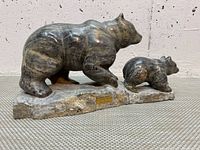 Left side view of carved stone mother bear and cub on base
