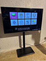 Front view of LG TV on pedestal stand displaying menu