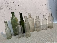 Front angled view of all ten bottles showing varied shapes, colors and heights