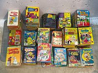 Overhead view of multiple stacks showing various titles such as Dennis the Menace, Richie Rich, Betty & Veronica, Archie, Peanuts, Woody Woodpecker