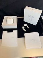 AirPods earbuds, charging case in box base, box lid, inserts displayed