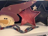 Snowman head with hat, red and black inset stars, small cream star