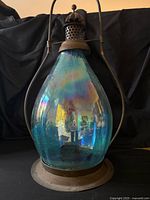 Front view of assembled lantern showing blue iridescent glass and metal frame