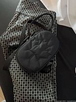 Leggings folded with geometric print alongside black shoulder bag