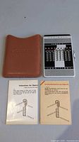 Adder, leather case, two instruction cards full view
