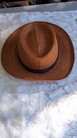 Top view of brown-rust straw fedora with braided band
